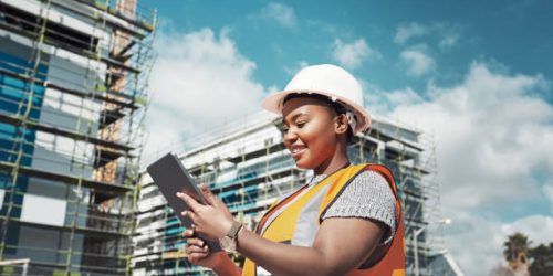 Pre Construction services Shot of a young woman using a digital tablet while working at a construction site